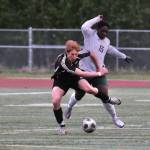 Juneau-Douglas High School: Yadaa.at Kalé senior Reed Maier battles with a Service player as teammates Kellen Chester and Erik Thompson (15) move into the play during the Crimson Bears win over Service to open the 2025 ASAA/First National Bank Alaska Soccer State Championships at Wasilla High School on Thursday, May 29, 2025. (Klas Stolpe / Juneau Empire)