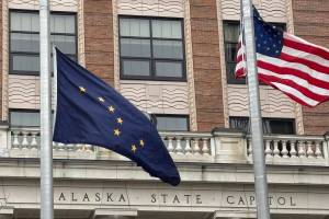 The Alaska and American flags fly in front of the Alaska State Capitol on Tuesday, April 22, 2025. (James Brooks/Alaska Beacon)