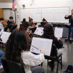 Serjoe Gutierrez plays violin with the Kodiak High School Orchestra during warm ups (Brian Venua/KMXT)