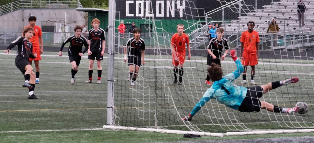 Juneau-Douglas High School: Yadaa.at Kalé senior Kai Ciambor hits a penalty kick past West Anchorage sophomore keeper Gideon Plikat during the Crimson Bears 3-2 loss in extra time to the Eagles in the 2025 ASAA/First National Bank Alaska Soccer State Championship semifinals Friday at Wasilla High School. (Klas Stolpe / Juneau Empire)
