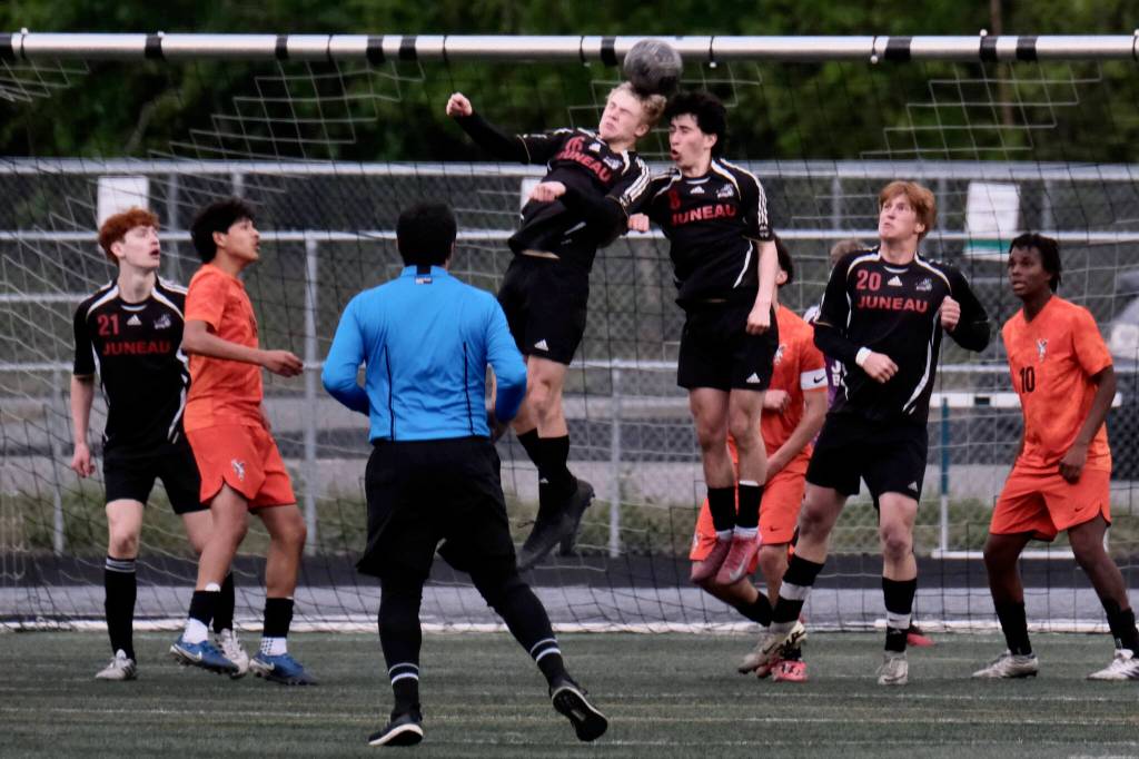 Juneau-Douglas High School: Yadaa.at Kalé sophomore Erik Thompson (21), junior Elliot Welch (16) and seniors Kellen Chester (8) and Reed Maier (20) stop a West Anchorage corner kick during the Crimson Bears 3-2 loss to the Eagles on Friday in the 2025 ASAA/First National Bank Alaska Soccer State Championship semifinals at Wasilla High School. (Klas Stolpe / Juneau Empire)