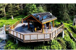 High school tech students install solar panels at the Anan Wildlife Observatory viewing cabin. (Ander Edens / Wrangell Sentinel)