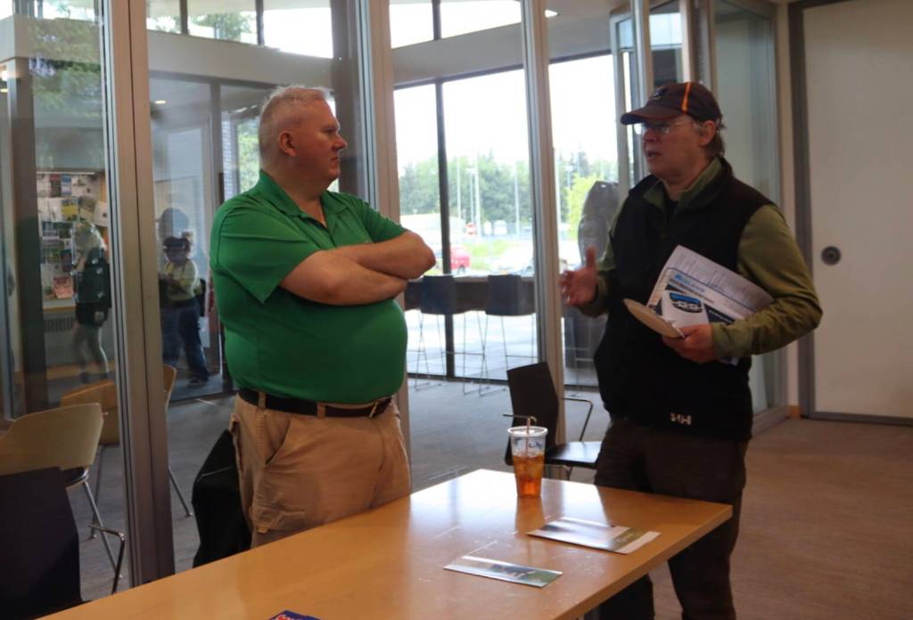 Insurance agent Emil Mackey discusses flood insurance with a Valley resident at the Juneau Flood Preparedness Workshop at the Mendenhall Valley Public Library on Saturday, Jun 7, 2025 (Ellie Ruel / Juneau Empire)