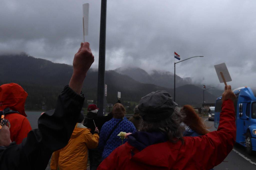 Participants wave at tour buses during the Cancer Survivors Day walk on Sunday, June 8, 2025. (Ellie Ruel / Juneau Empire)