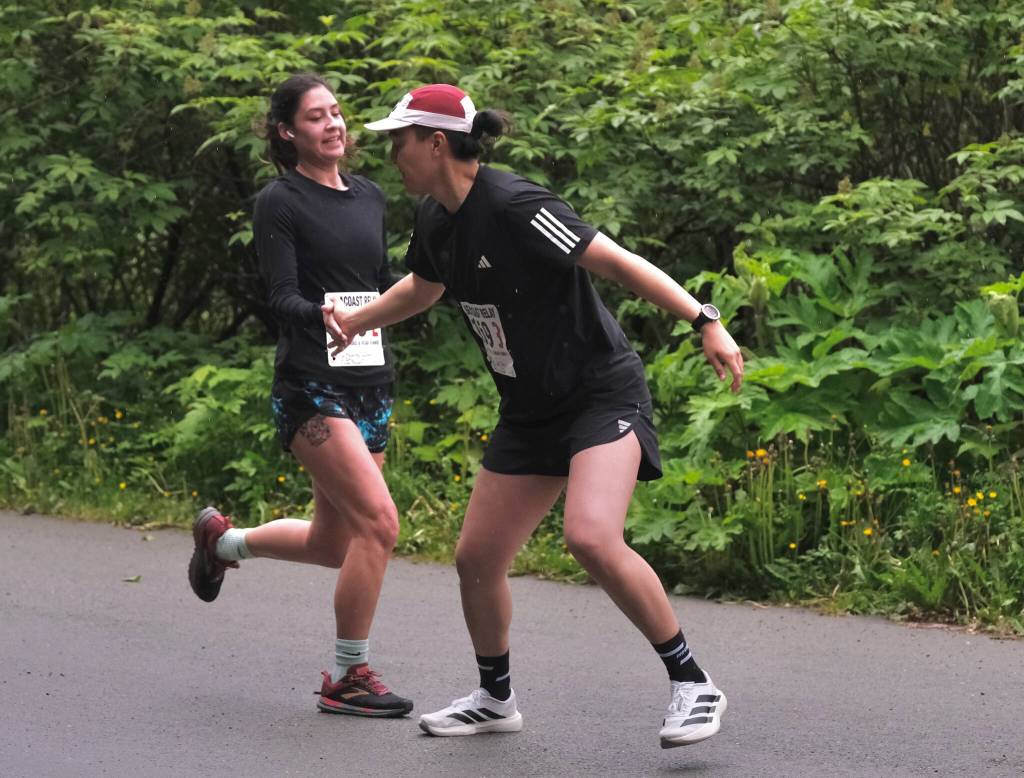 Snow Doubts Trinity Jackson hands off to Ricardo Worl at the Auke Village Recreation Area during the Seacoast Relay on Sunday, June 8, 2025. (Klas Stolpe / Juneau Empire)
