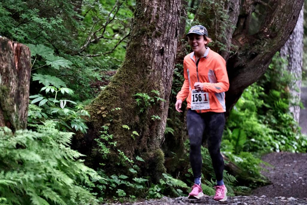 Team JACKD runner Claire Geldhof races on Auke Lake Trail in the first leg of the Seacoast Relay on Sunday, June 8, 2025. (Klas Stolpe / Juneau Empire)