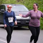 Sole Sisters Sara Race and Lacey Sanders hand off at the Auke Village Recreation Area during the Seacoast Relay on Sunday, June 8, 2025. (Klas Stolpe / Juneau Empire)