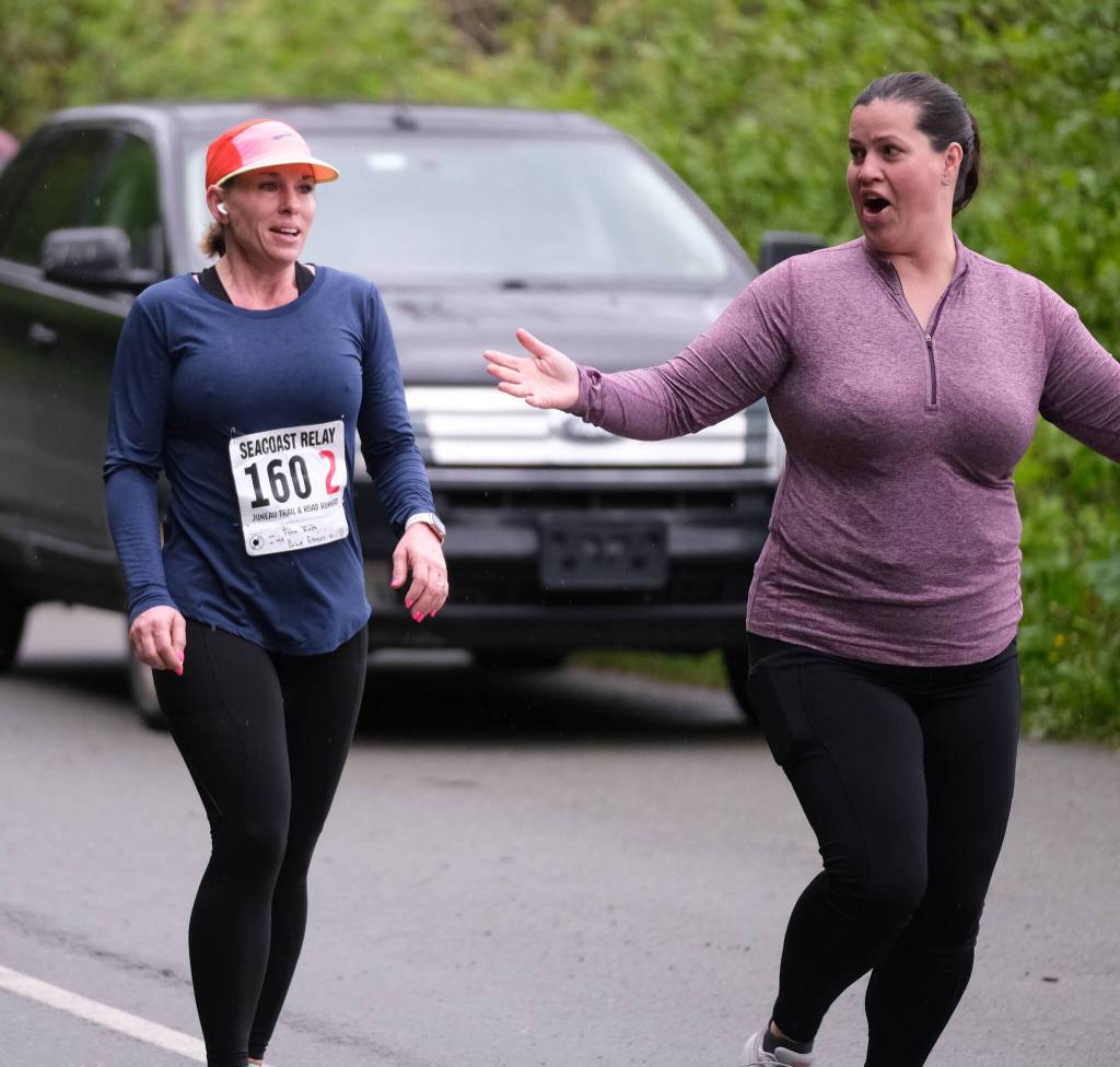 Sole Sisters Sara Race and Lacey Sanders hand off at the Auke Village Recreation Area during the Seacoast Relay on Sunday, June 8, 2025. (Klas Stolpe / Juneau Empire)
