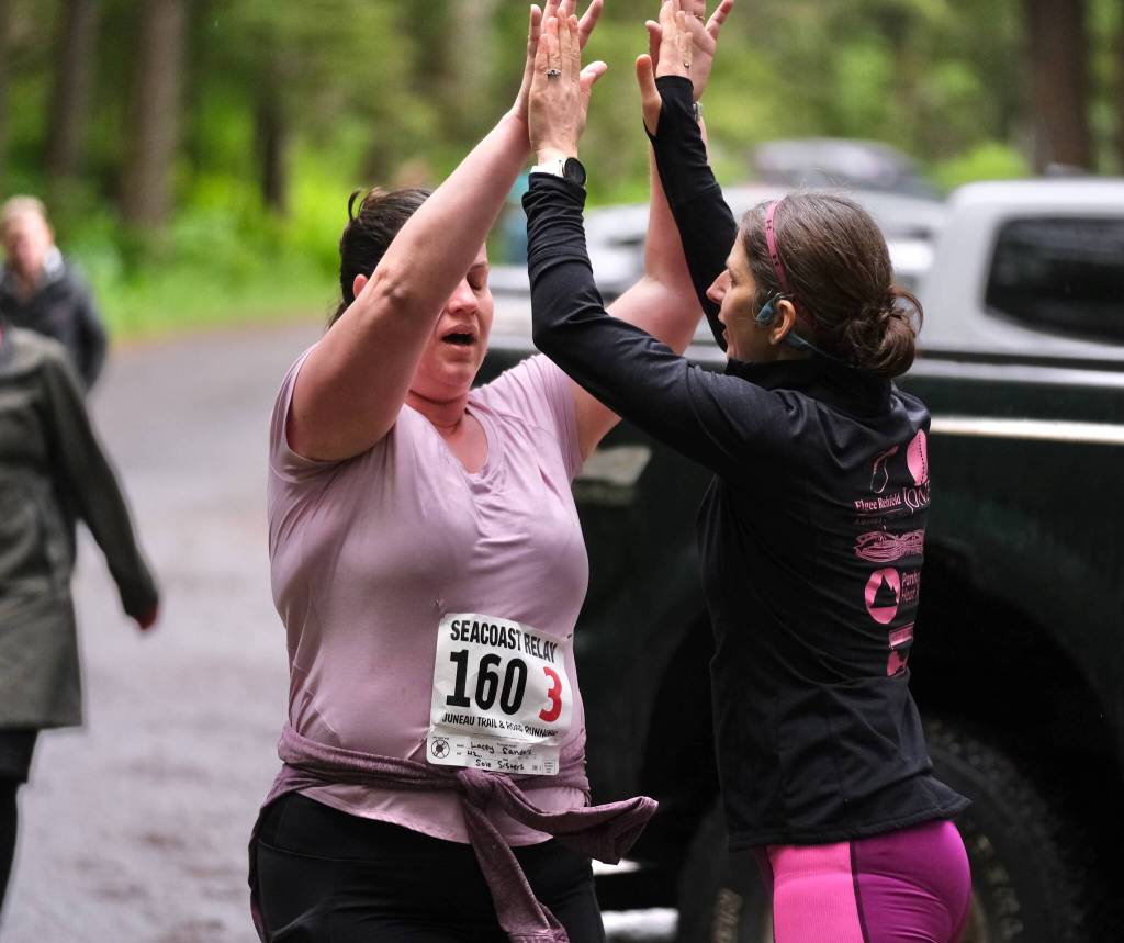 Team Sole Sisters Lacey Sanders hands off to Julie Mesdag at Lena Beach Picnic Area during the Seacoast Relay on Sunday, June 8, 2025. (Klas Stolpe / Juneau Empire)