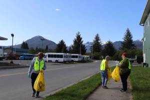 Volunteers look for trash on the Jordan Avenue sidewalk at JAMHIs Community Litter Pickup event on Saturday, June 14, 2025. (Ellie Ruel / Juneau Empire)