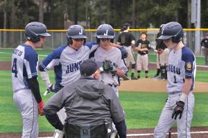 Juneaus Auke Bay Post 25 players Hunter Carte, JJ McCormick, Micaw Nelson and Noah Lewis listen to manager Joe Tompkins during last weekends action against Anchorages South Post 4 at Adair Kennedy Memorial Park. (Klas Stolpe / Juneau Empire)