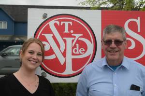 Jennifer Skinner and Dave Ringle stand by the St. Vincent de Paul logo on Thursday, June 19, 2025. (Natalie Buttner / Juneau Empire)