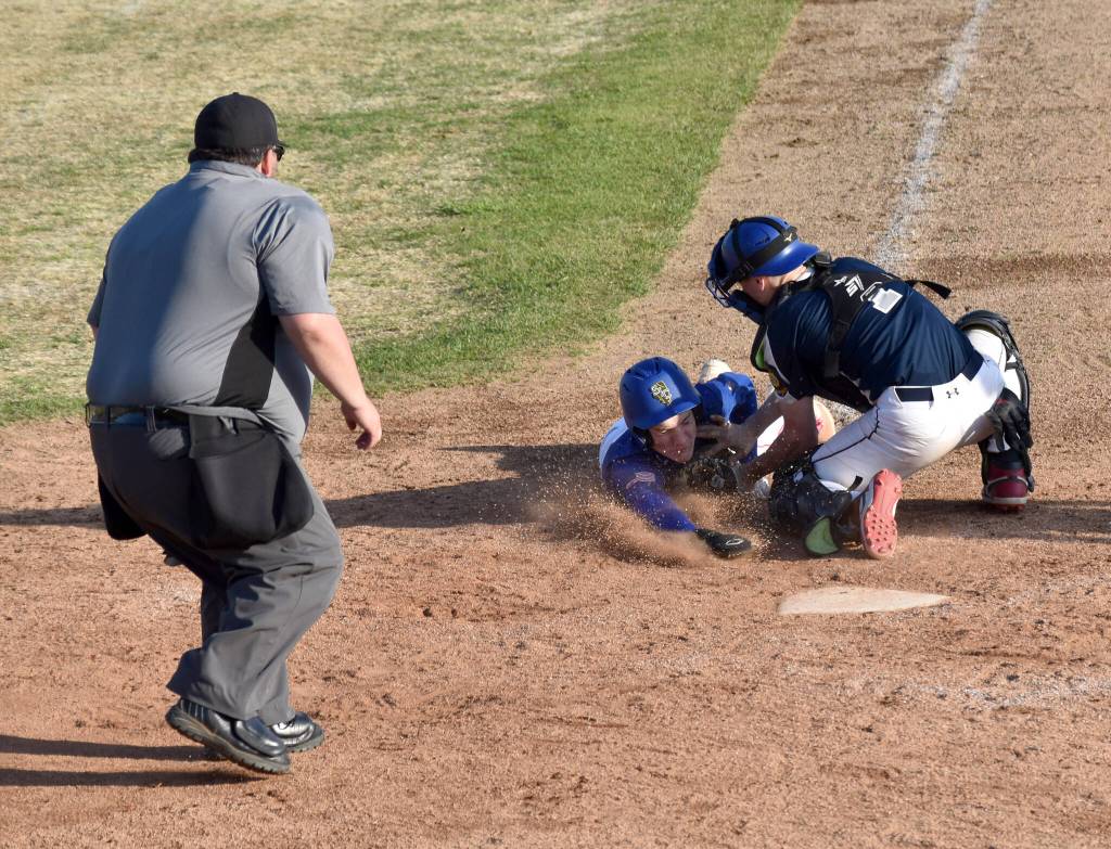 Xzavier Martin of Madisonville (Kentucky) Post 6 scores against Noah Lewis of Auke Bay Post 25 on Friday, June 20, 2025, in the Lance Coz Wood Bat Tournament at Coral Seymour Memorial Park in Kenai, Alaska. (Photo by Jeff Helminiak/Peninsula Clarion)