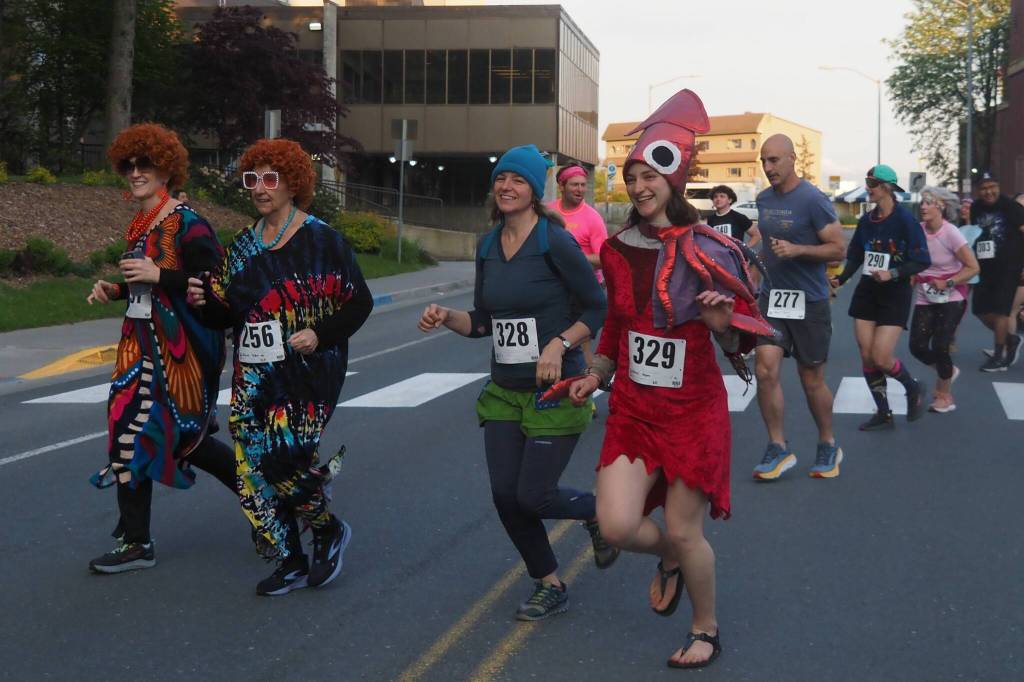 Runners cross Willoughby Avenue on Friday, June 20, 2025. Leading the pack are Adeline Souza and Heather Jones dressed as Mrs. Roper from the 1970s sitcom Threes Company. They were inspired by the nationwide phenomenon Mrs. Roper Romps. (Natalie Buttner / Juneau Empire)