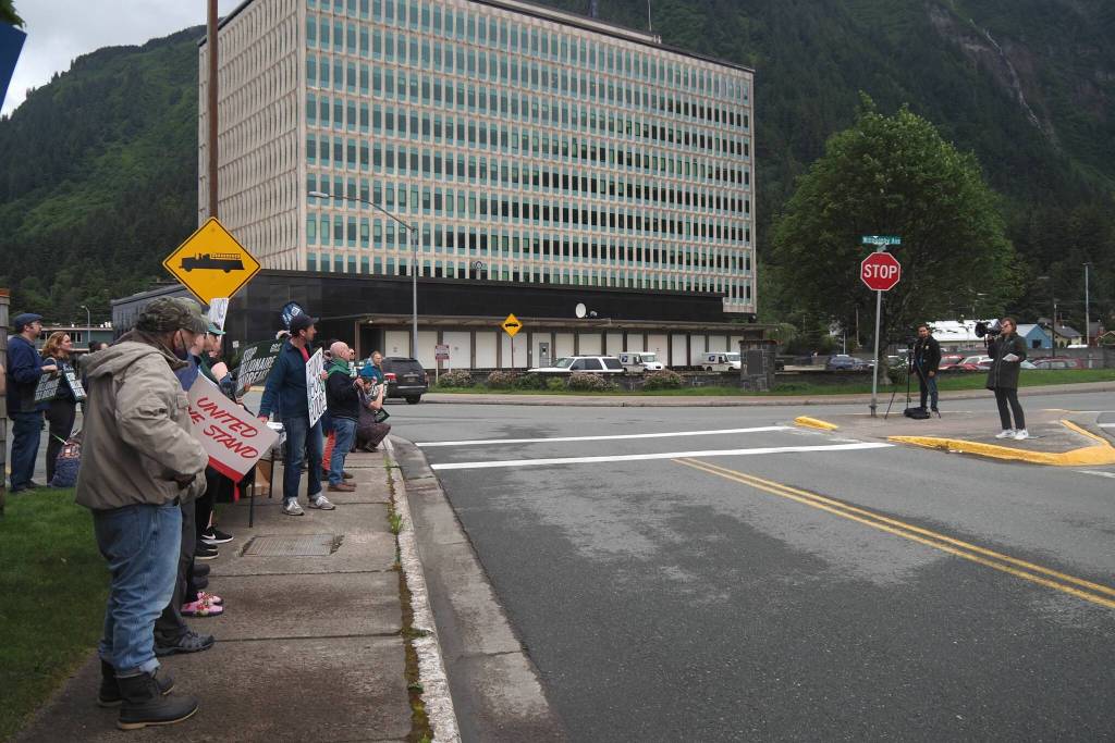 Demonstrators listen to speaker Heidi Drygas, executive director of Alaska State Employees Association on Friday, June 27, 2025. (Natalie Buttner / Juneau Empire)