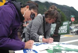 Megan Lingle writes a postcard to Alaska state senators on Friday, June 27, 2025. (Natalie Buttner / Juneau Empire)