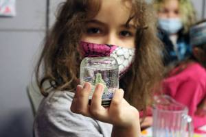 Skylar Taug, 6, holds up a snow globe following a crafts project Tuesday afternoon during RALLY. We try for a Wow! every day, said Christina Ackmann, RALLY site manager for Sít Eetí Shaanáx-Glacier Valley Elementary School. (Ben Hohenstatt / Juneau Empire file photo)