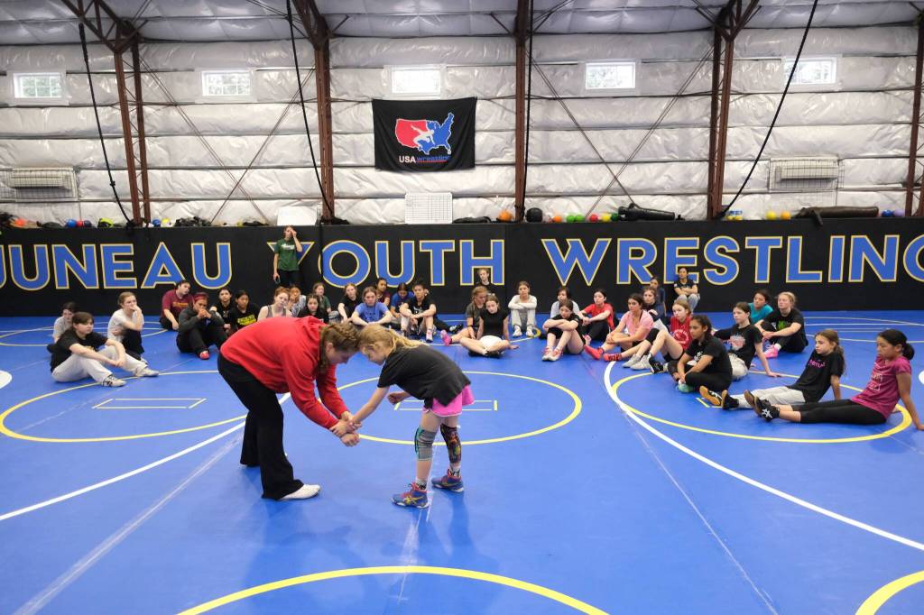 2024 Olympic wrestling gold medalist Amit Elor, 21, center, demonstrates a counter move on Anchorage fifth grader Pia Kopiasz, 10, during the Juneau Girls Wrestling Clinic on Wednesday at the Juneau Wrestling Center. (Klas Stolpe / Juneau Empire)
