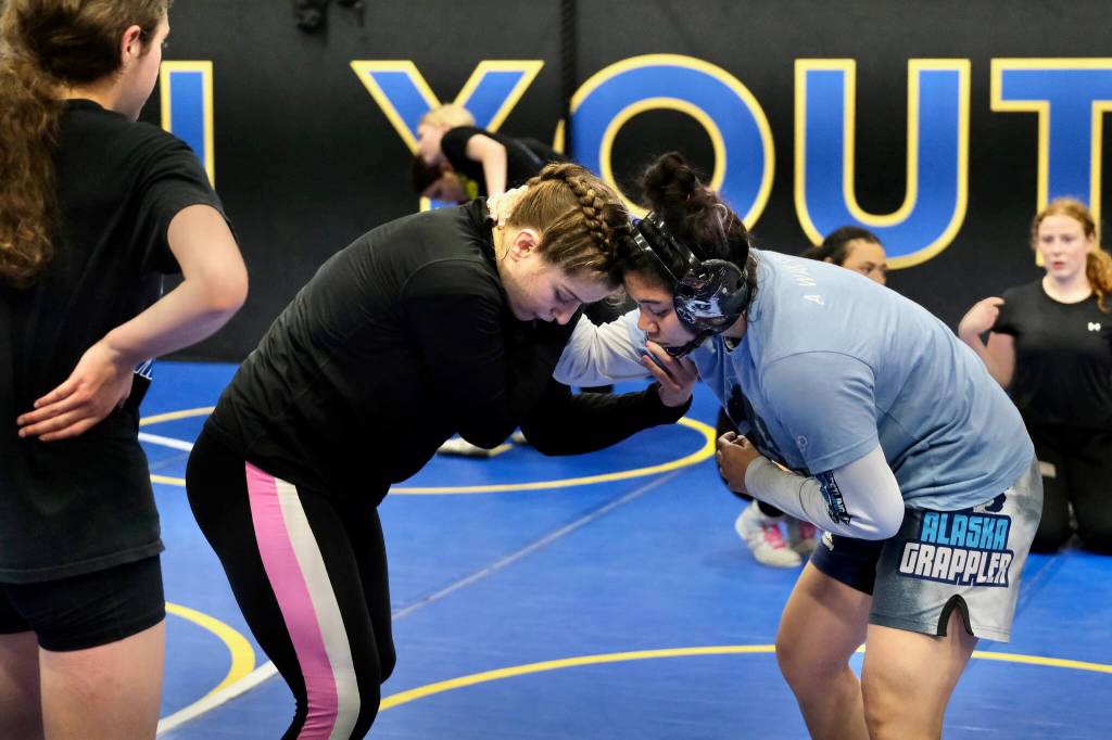 2024 Olympic wrestling gold medalist Amit Elor, 21, center, demonstrates a counter move on 2025 Colony High School graduate, and state champion, Amelia Fawcett, 18, during the Juneau Girls Wrestling Clinic on Tuesday at the Juneau Wrestling Center. (Klas Stolpe / Juneau Empire)