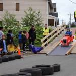 Volunteers roll riders down the ramp for soapbox derby time trials on St. Anns Avenue on Thursday, July 3, 2025. (Ellie Ruel / Juneau Empire)