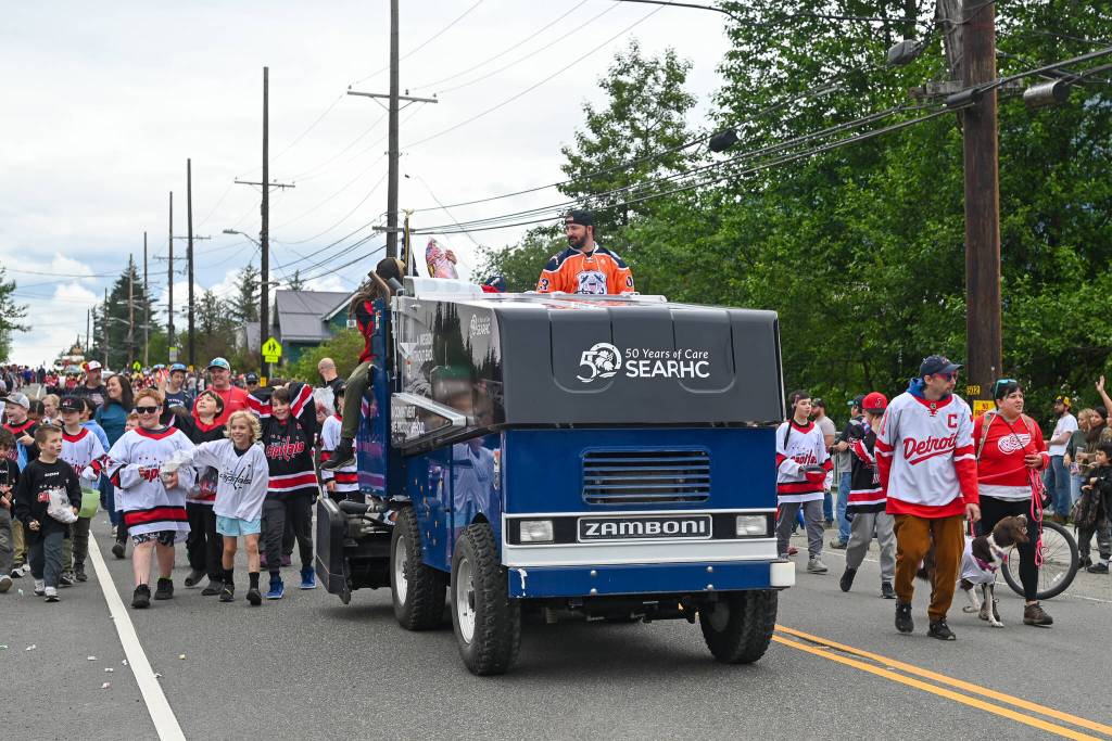 Hockey team members walk alongside the Treadwell Arena Zamboni on Friday, July 4, 2025. (Jasz Garrett / Juneau Empire)