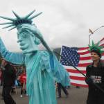 The Statue of Liberty puppet moves down Egan Street Drive during the downtown parade on July 4, 2025. Laura Lucas controls the puppets left hand, Bob Banghart controls its right, and SueAnn Randall is inside. (Natalie Buttner / Juneau Empire)
