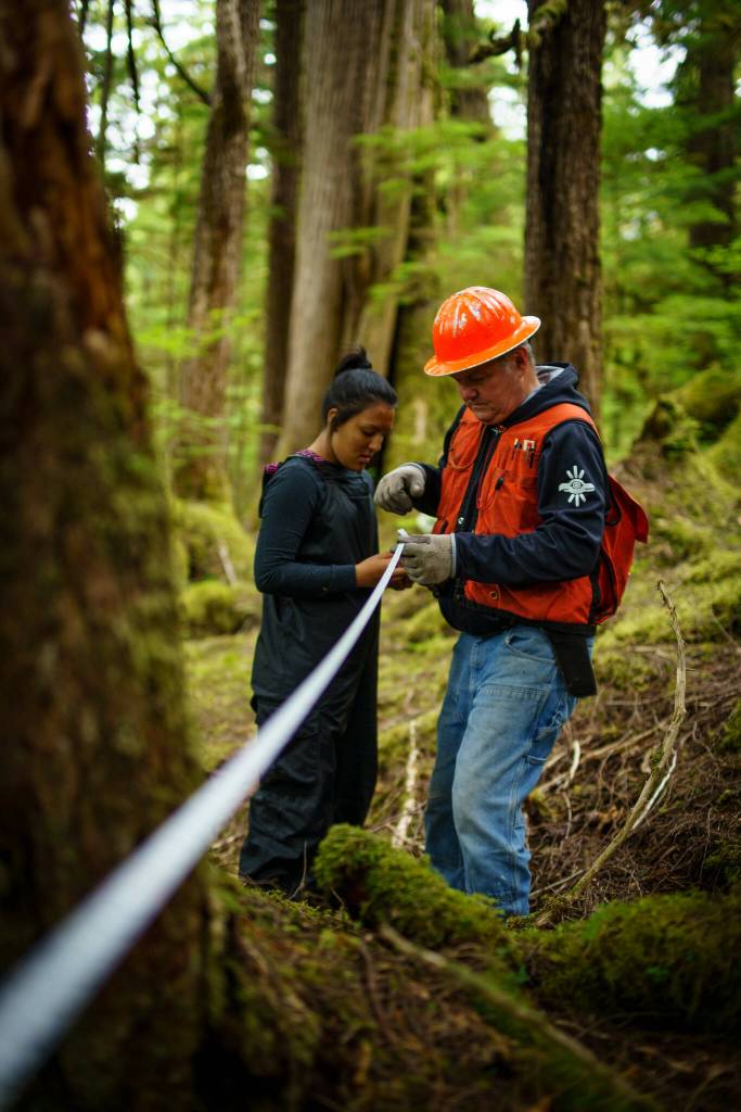 Bob Girt works with youth on Prince of Wales Island in 2022, and gives instructions on how to take forestry measurements. (Photo courtesy of Bethany Goodrich / Sustainable Southeast Partnership)