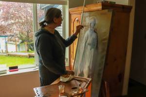 Photo by Charles Whittlesey
Tatiana McWethy demonstrates her restoration technique on the icon of St. Nicholas.