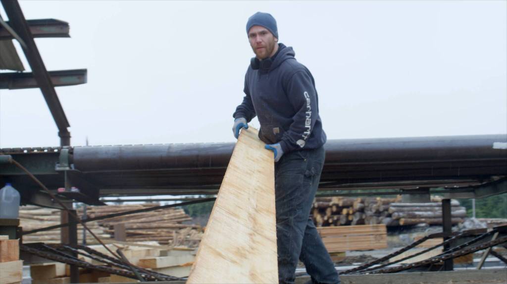 A Viking Lumber employee pulls lumber from the green chain after it has gone through the mill. (Courtesy of Viking Lumber Company)