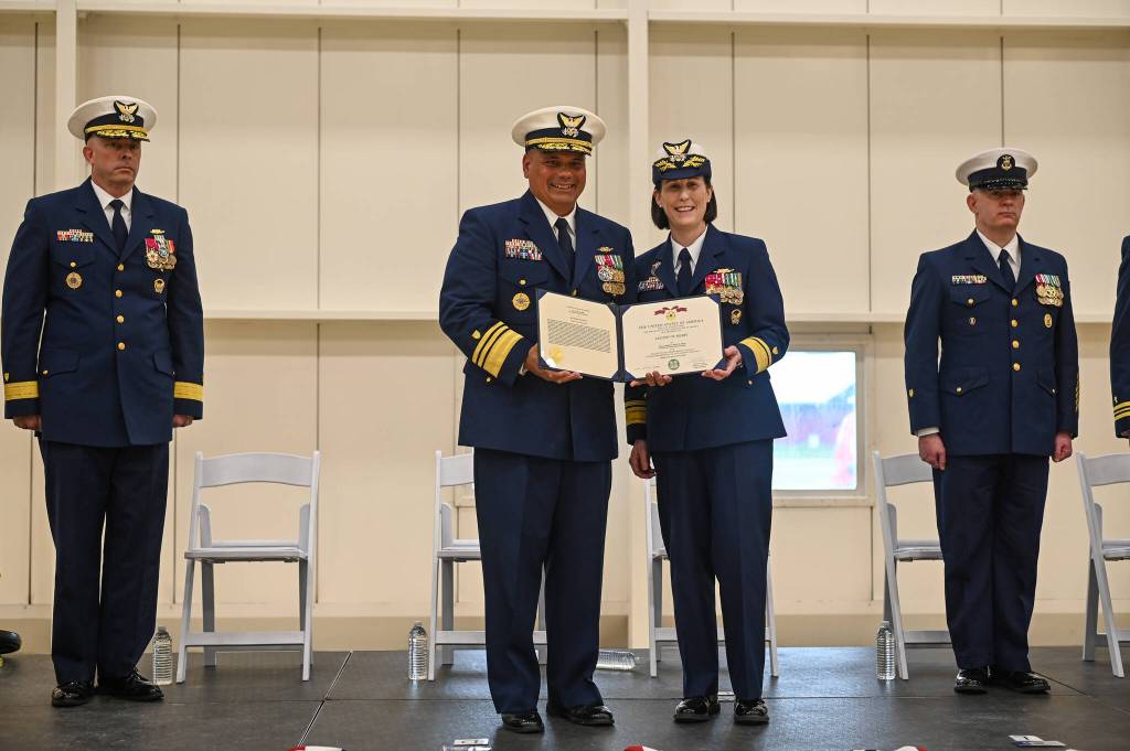 Vice Admiral Andrew J. Tiongson, commander of the Pacific Area, awards Rear Admiral Megan Dean with an Outstanding Meritorious Service citation for her time serving as Arctic District commander from June 2023 to July 2025. (Jasz Garrett / Juneau Empire)