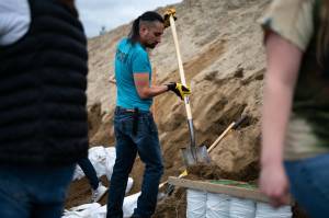 Kai Monture shovels sand into bags at a City and Borough of Juneau and Tlingit & Haida collaborative event distributing sandbags to residents, Saturday<ins>, July 19, 2025, in Juneau, Alaska</ins>. Monture does not live in the flood zone, but came out to volunteer to take care of community. Its an important value to me. (Carly Rundle-Borchert/Juneau Empire)