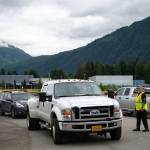 Bob Beard directs vehicles coming in to pick up sand at a City and Borough of Juneau and Tlingit & Haida collaborative event distributing sandbags to residents, Saturday, July 19, 2025, in Juneau, Alaska. Beard lives in Jupiter, Florida, but took time to volunteer at the event while in Juneau visiting his son. (Carly Rundle-Borchert/Juneau Empire)