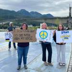 Protesters hold signs at the No War Criminals protest at The Whale in Bill Overstreet Park in Juneau, Alaska, on Friday, Aug. 15, 2025. (Photo provided by Juneau For Democracy)