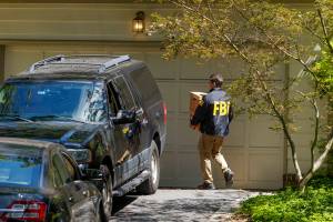 FBI agents leave with boxes from the home of John Bolton, President Trumps former national security adviser, after serving a warrant in Bethesda, Md., Aug. 22, 2025. The investigation into Bolton began to pick up momentum during the Biden administration, when U.S. intelligence officials collected information that appeared to show that he had mishandled classified information, according to people familiar with the inquiry. (Jason Andrew/The New York Times)
