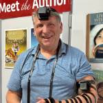Alexander Dolitsky participates in a traditional Jewish blessing,  in which two leather boxes (tefillins) are secured around a person's head and arm, at Hearthside Books in the Merchant Wharf Mall in downtown Juneau, August 2025. (Photo provided by Alexander Dolitsky)