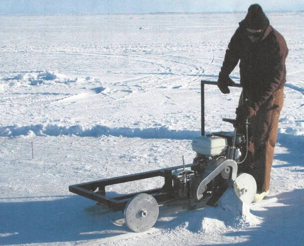 Lew Shapiro cuts into sea ice north of Utqiaġvik, then called Barrow, during his long career with the Geophysical Institute. (Photo courtesy of UAF Geophysical Institute)