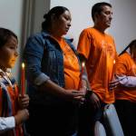 Eight-year-old Floyd Azure Jr. stands with his parents Heather and Floyd Azure during a candlelight vigil as part of a National Day of Remembrance of boarding school survivors and families hosted Tuesday, Sept. 16, 2025, by the National Native American Boarding School Healing Coalition in Washington, D.C. His mother, Heather, attended Flandreau Indian School. (Credit: Charles Fox for ICT)