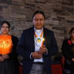 Jason Packineau, center, senior director of strategic initiatives for the National Native American Boarding School Healing Coalition leads a prayer at a National Day of Remembrance Event and candlelight vigil hosted by NABS on Tuesday, Sept. 16, at the Indian Gaming Association in Washington, D.C. They honored U.S. Indian boarding school survivors and the children who never returned home. (Credit: Charles Fox for ICT)
