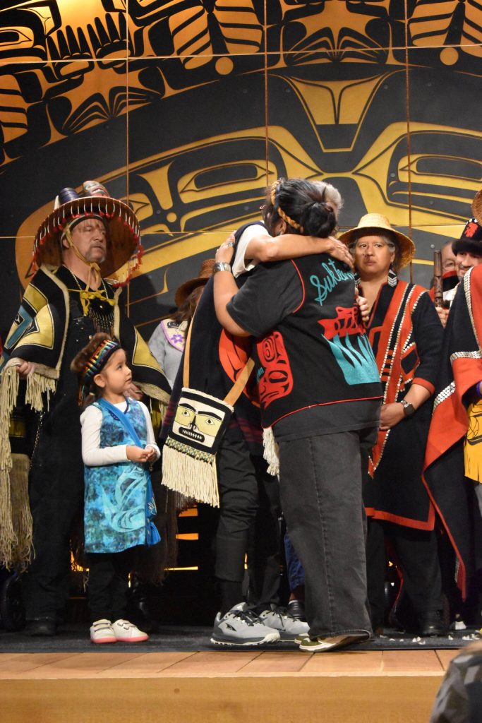 Eva Rowan embraces Lee Wallace, a Haida master carver who led the creation a Sukteeneidí Clan totem pole joining the ranks of SHIs Kootéeyaa Deiyí Totem Pole Trail.