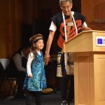 Photos by Mari Kanagy / Juneau Empire
Haida master carver Lee Wallace takes the hand of his granddaughter and carving apprentice, Elizabeth Peele. Wallace led the carving of the Sukteeneidí clan totem pole which was dedicated at the Sealaska Heritage Institute ceremony on Monday.