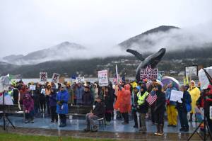 Protesters stand amidst the rain and fog at the No Tsars, No Kings protest on Saturday, Oct. 18 at Overstreet Park. (Mari Kanagy/Juneau Empire)