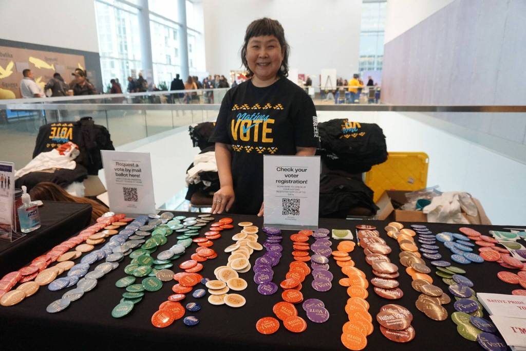 Kendra Berlin mans a pro-voting table at the Alaska Federation of Natives convention on Oct. 16, 2025. Berlin, originally from Bethel but now living in Palmer, was distributing T-shirt and buttons promoting the Natives Vote cause.