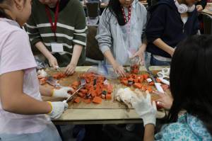 Young people cutting salmon at the First Alaskans Institute Elders & Youth Conference, which took place in Anchorage from Oct. 12-15. (Photo courtesy of Aaron Angerman).