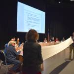 Two people unroll a petition with the names of 847 signees against the city's plan to demolish the houses on Telephone Hill and build higher-density housing at the Assembly meeting on Monday, Oct. 27. (Mari Kanagy/Juneau Empire)