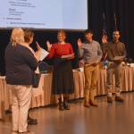 Left to right: Juneau Mayor Beth Weldon stands as Municipal Attorney Emily Wright swears in Assembly member Ella Adkison, Greg Smith and Nano Brooks at the Assembly meeting on Monday, Oct. 27. (Mari Kanagy/Juneau Empire)