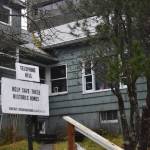 A sign reading, Help Save These Historic Homes is posted in front of a residence on Telephone Hill on Friday Nov. 21, 2025. (Mari Kanagy / Juneau Empire)