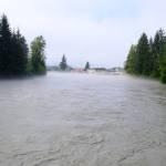 Photo by Corinne Smith/Alaska Beacon
The Mendenhall River is seen at flood levels, just a few hours after the record-breaking peak of 16.65 feet, from the Brotherhood Bridge in Juneau on Aug.13, 2025. The flood, caused by an outburst of meltwater from Mendenhall Glacier, was mentioned in the 2025 Arctic Report Card as one of the impacts of glacial melt.