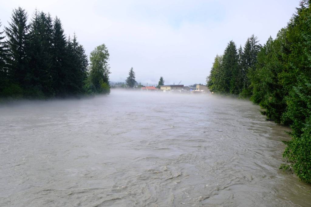 Photo by Corinne Smith/Alaska Beacon
The Mendenhall River is seen at flood levels, just a few hours after the record-breaking peak of 16.65 feet, from the Brotherhood Bridge in Juneau on Aug.13, 2025. The flood, caused by an outburst of meltwater from Mendenhall Glacier, was mentioned in the 2025 Arctic Report Card as one of the impacts of glacial melt.