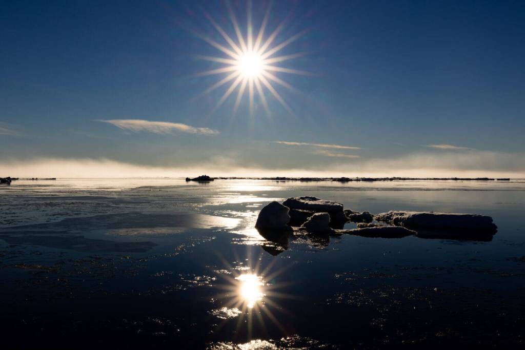 Lisa Hupp/USFWS
The sun at midnight in early July reflects on the Chukchi Sea and slabs of sea ice near the coastline of Utgiagvik.