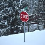 Dense, wet snowpack piles up beneath a stop sign on Great Western street. (Mari Kanagy / Juneau Empire)